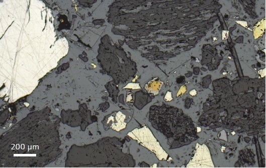 Reflected light image acquired with ZEISS Axiolab 5. Sample of mil led copper ore mounted in a resin block and previously prepared for SEM analysis. Remnants of a carbon coating remain on some surfaces.
